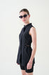 Woman wearing a black sleeveless dress with a belt on a white background from the Buttercups uniforms collection