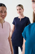 Zoomed in three women wearing different coloured beauty uniforms