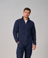 A man wearing a navy blue zip-up fleece jacket and matching navy cargo pants, standing against a solid light gray studio background.