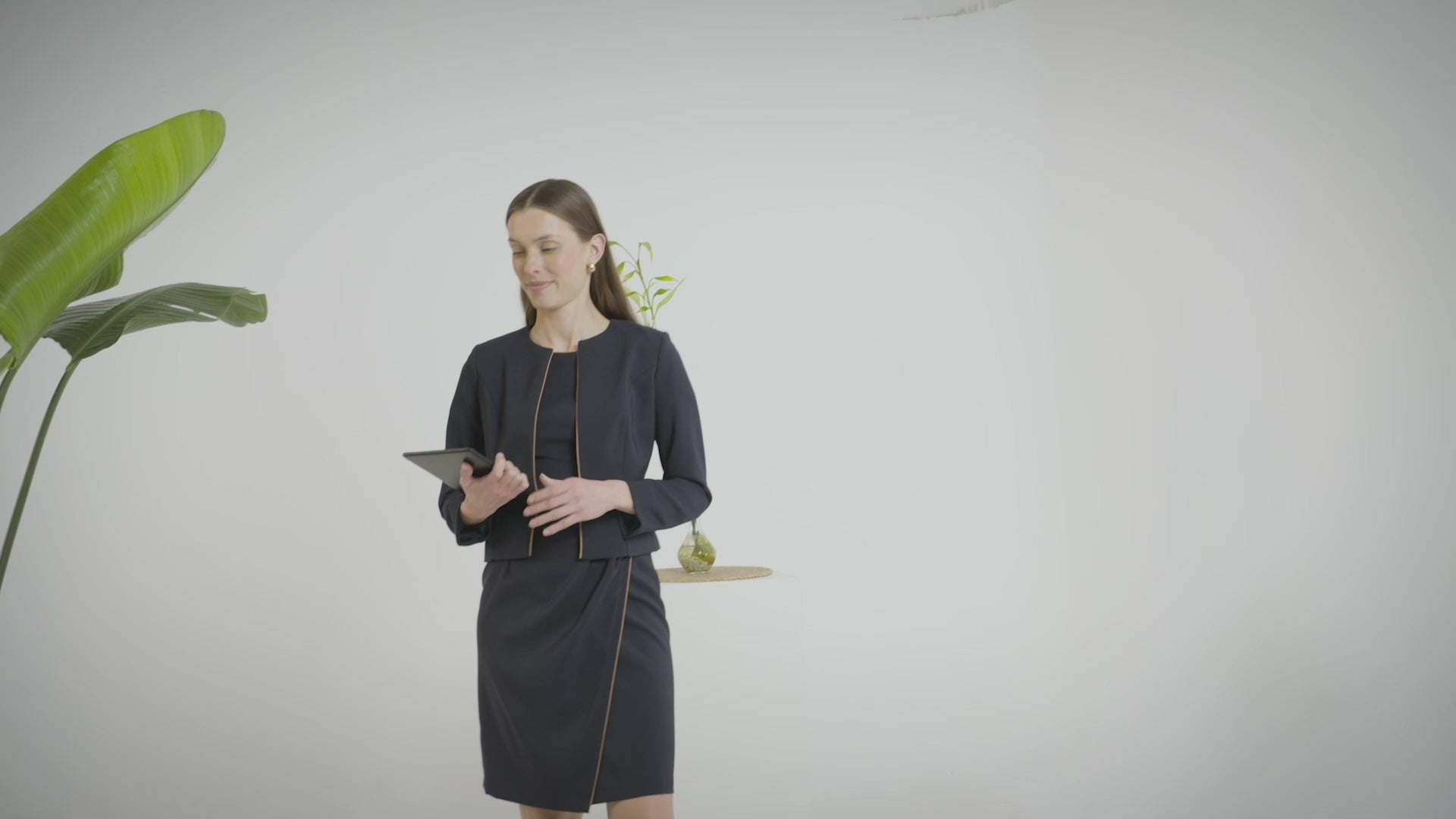 Woman wearing the Navy Chic Jacket with a tablet in hand.